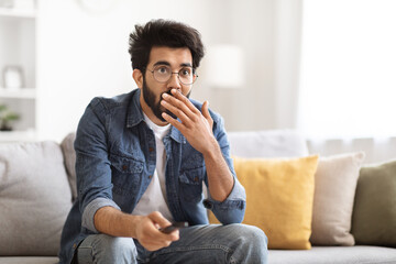 Portrait Of Amazed Indian Guy Holding Remote Controller And Looking At Tv