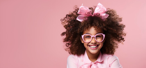 happy laughing curly girl in pink glasses with a bow in her hair, banner with copy space