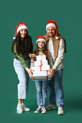 Happy family with Christmas presents on green background