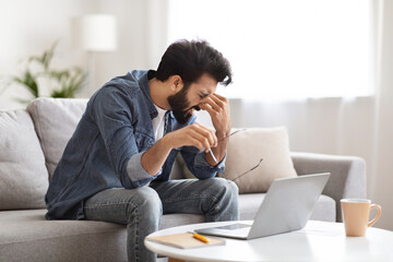 Young Indian Male Freelancer Tired After Working On Laptop Computer At Home