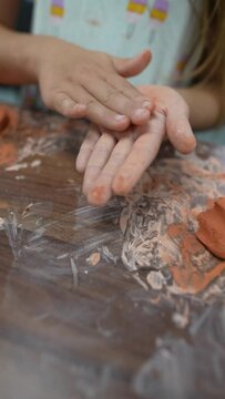 On the wooden crafting table, kids are shaping clay figures.