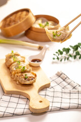 Original Japanese dumplings Gyoza with chicken and vegetables. Chopsticks holding Japanese Pan-fried gyoza 