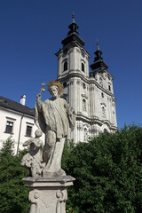Fototapeta na wymiar Statue und Stiftskirche in Spital am Pyhrn