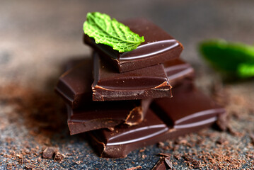 Dark chocolate slices with fresh mint .
