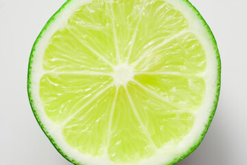 Slice of fresh green lime with green rind on white background. Photo. Macro. Daylight.