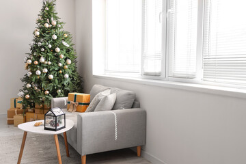 Interior of festive living room with grey sofa and gift boxes under Christmas tree
