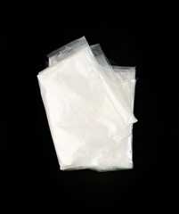 Folded White Plastic Bags on Black Background, Crumpled Plastic Bag after Shopping, Cellophane Packaging Waste