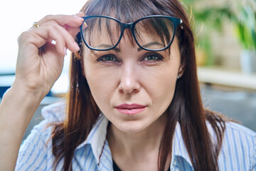Close-up of the face of mature woman in glasses, an attentive looking look
