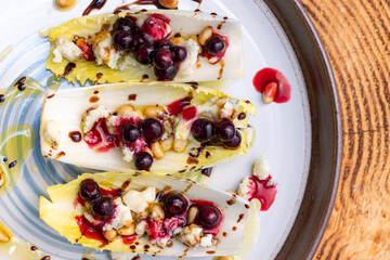 Belgium endive boats with huckleberries, nuts and cheese