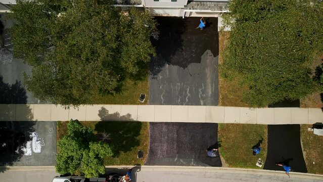 Aerial shot of Driveway sealcoating pavement, Near private houses in the suburbs. Top view footage