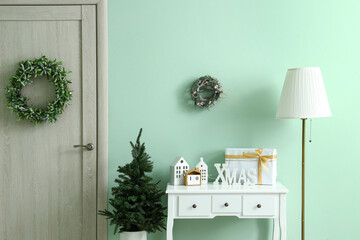 Interior of festive hallway with dressing table, standard lamp and Christmas decorations