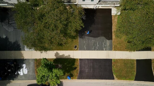 Aerial footage of Driveway sealcoating pavement, Near private houses in the suburbs. Top view footage