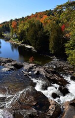 Autumn landscape along the shores of the Devils river side arm, near the cascade waterfall in Mont-Tremblant, Quebec Canada