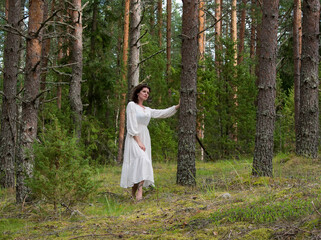 Beautiful woman in a white dress in the forest