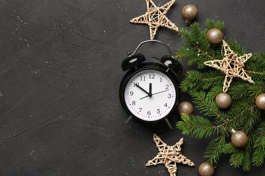 Alarm Clock And Christmas Tree Branches With Balls On Black Background