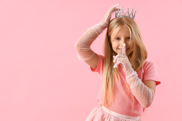 Cute little girl in tiara showing silence gesture on pink background © Pixel-Shot