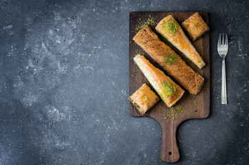 Traditional turkish dessert concept, kadayif, carrrot slice,  antep baklava with pistachio on rustic background