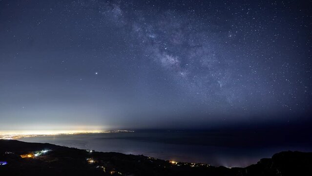 Time Lapse of the starry night sky and the Milky Way rising over the glowing lights of Los Angles