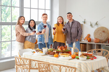 Group of young friends with punch having dinner on Thanksgiving Day