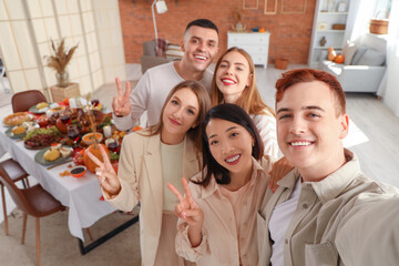 Group of young friends taking selfie at home on Thanksgiving Day