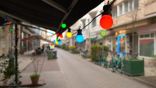 Colorful lanterns by cafe fasade. A view of colorful lanterns burning in cafe in the day street.