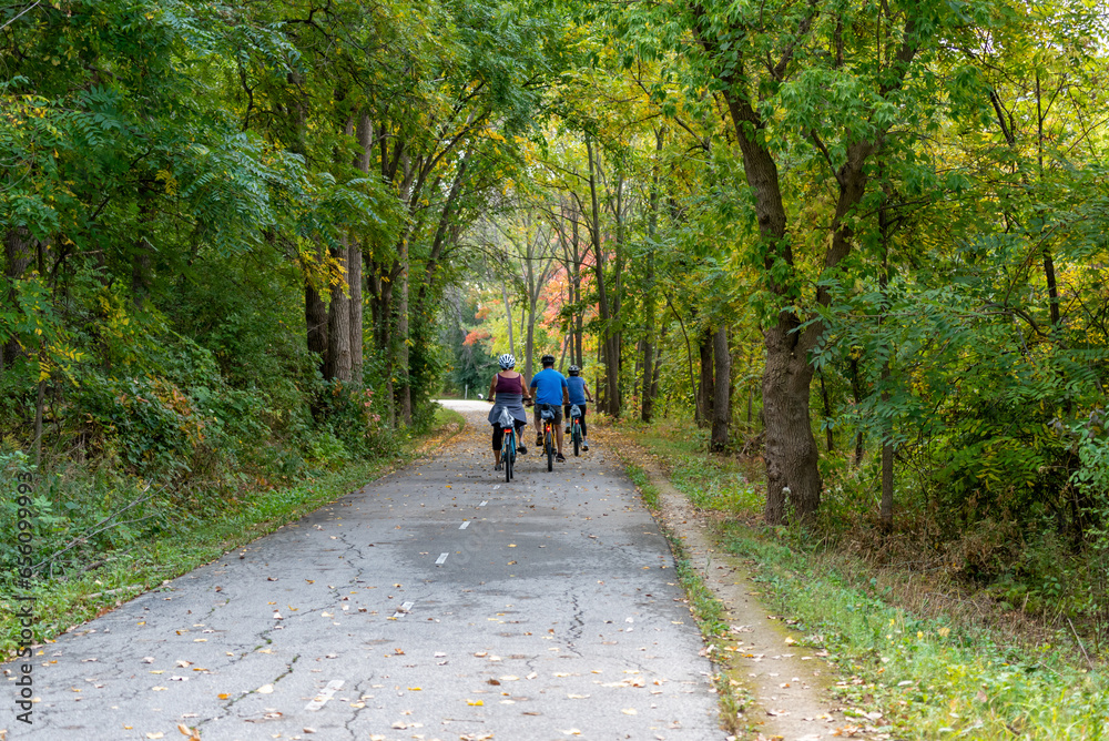 Sticker people on bicycles enjoying a fall day on the fox river trail near de pere, wisconsin