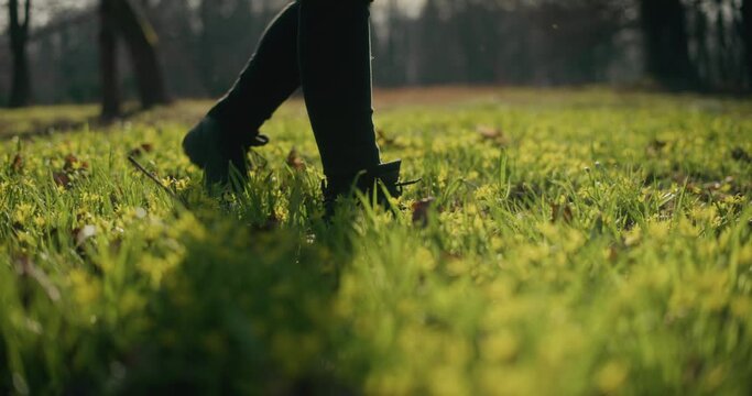 Woman wearing black shoes walking on grass