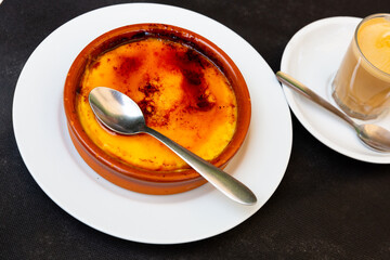 Tasty sweet custard crema catalana with browned crunchy layer of hardened caramelized sugar. Popular dessert of Spanish cuisine..