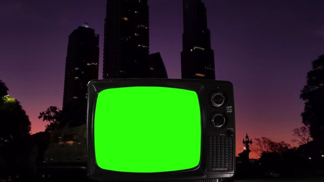Vintage TV Green Screen with High-rise Buildings at Sunset in the Background. You can replace green screen with the footage or picture you want with “Keying” effect in After Effects. 4K.