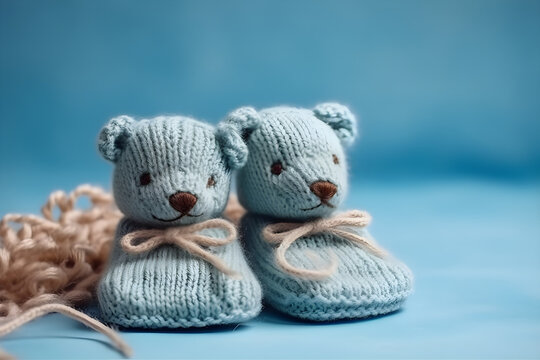 Cute blue knitted baby booties on a blue background with copyspace. Gender Reveal concept, Flat lay, top view, for banner background
