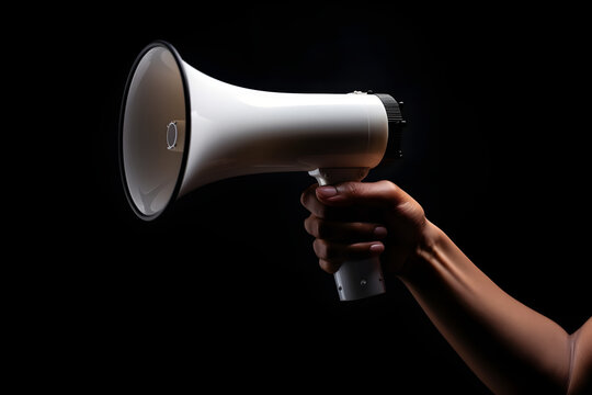 Hand holding megaphone isolated on black background with copyspace. Advertisement mock up, clip art, announcement and communication creative banner background concept