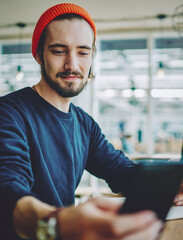  positive hipster guy checking notification on cellular phone
