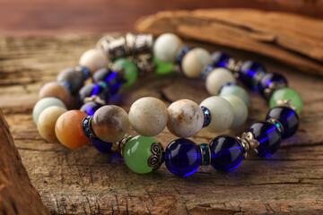 Beautiful bracelets with gemstones on wooden table, closeup