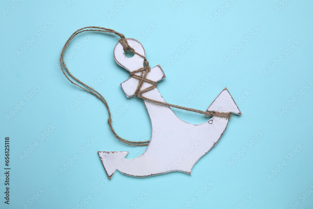 Poster White wooden anchor figure on light blue background, top view