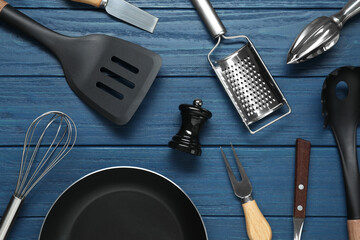 Set of different kitchen utensils on blue wooden table, flat lay