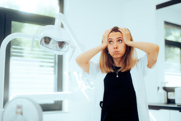 Exasperated Stressed Dentist Feeling Concerned Standing in her Cabinet. Dental care worker being...