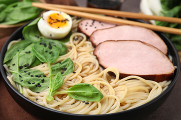 Delicious ramen with meat on table, closeup. Noodle soup