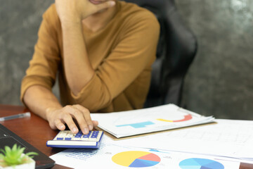 Young Asian entrepreneur working on financial papers at home. The businessman who run a startup company calculating and doing bill invoice at his desk workplace.