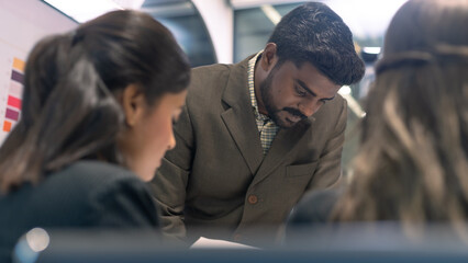 Fototapeta premium An Indian business boss giving briefs to team worker. Business communication in a teamwork meeting.