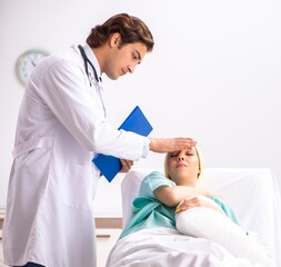 Young handsome doctor visiting female oncology patient