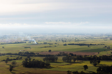 Fototapeta premium Controlled Burns Within Agricultural Landscape Creating a Rustic Countryside Scene