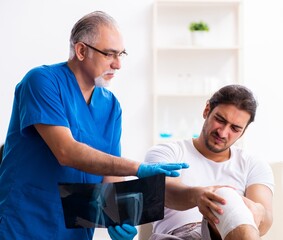 Obraz premium Leg injured man visiting old doctor in first aid concept