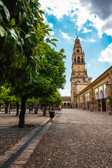 Low Angle View of Mezquita Cathedral's Bell Tower from Orange Tree Courtyard in Cordoba, Spain - obrazy, fototapety, plakaty