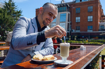 adult caucasian french man with beard business executive having breakfast outside restaurant