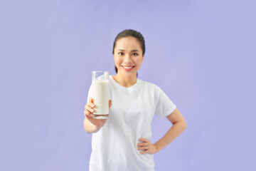 Pleased beautiful woman with a glass of milk in her hand looking
