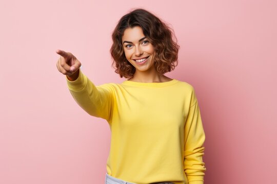 Woman pointing forward with her finger finger against blue background