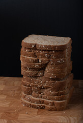 Sliced oat bread on wooden background. Still life concept. Dark moody. 