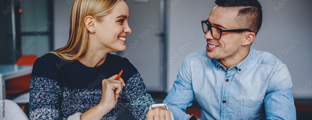 Canvas Prints Cheerful young man and woman talking about collaborative plan on common project