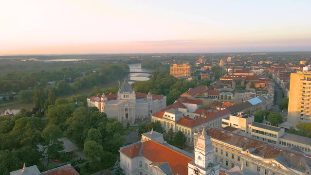Aerial footage over Arad city center with the Cultural palace and Administrative palace in the view. Video was shot from a drone, in the morning, while flying backwards with camera level.