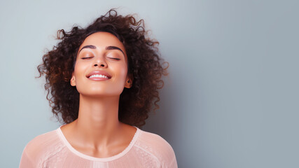 A woman closed eyes breathes relaxedly isolated on pastel background